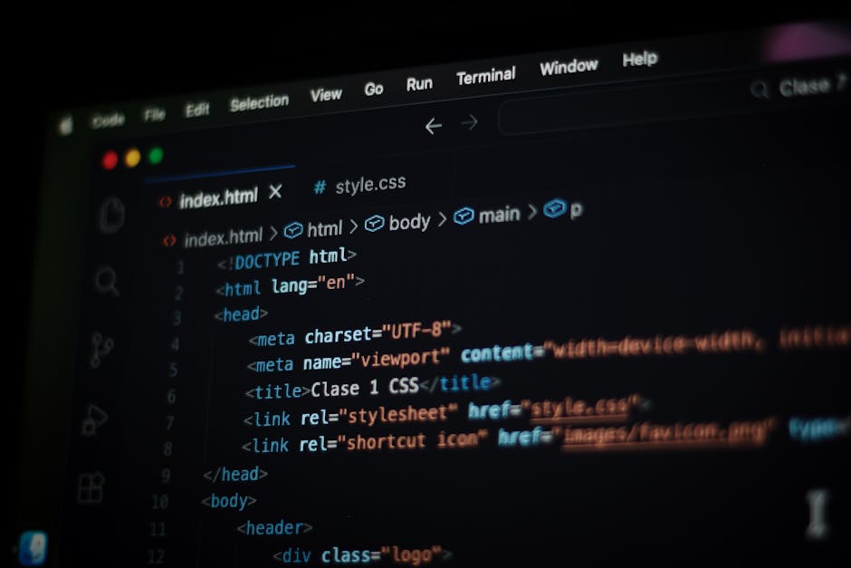 A close-up view of a laptop sitting on a wooden desk, displaying lines of coding and script in various colors on a dark background. Positioned next to the laptop is a ceramic coffee mug with a beige e